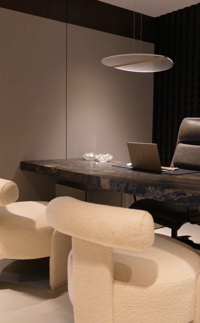 Consultório do NÚCLEO DREO com mesa de pedra e iluminação suspensa